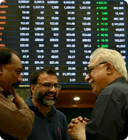 Traders on the Pakistan Stock Exchange floor in front of the price board